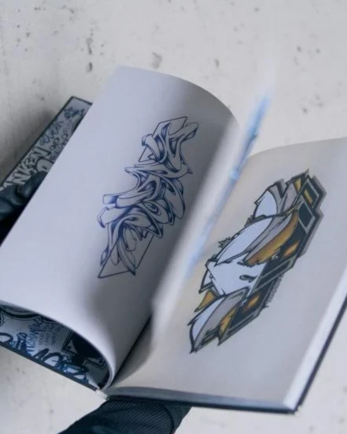 Astrofat DOES First 20 Years hardcover book showing graffiti sketches and handwritten notes on open pages
