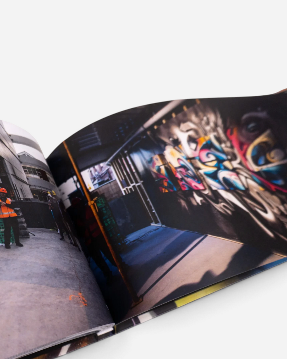 Astrofat DOES First 20 Years book open to pages showing vibrant graffiti mural photography and street art sketches
