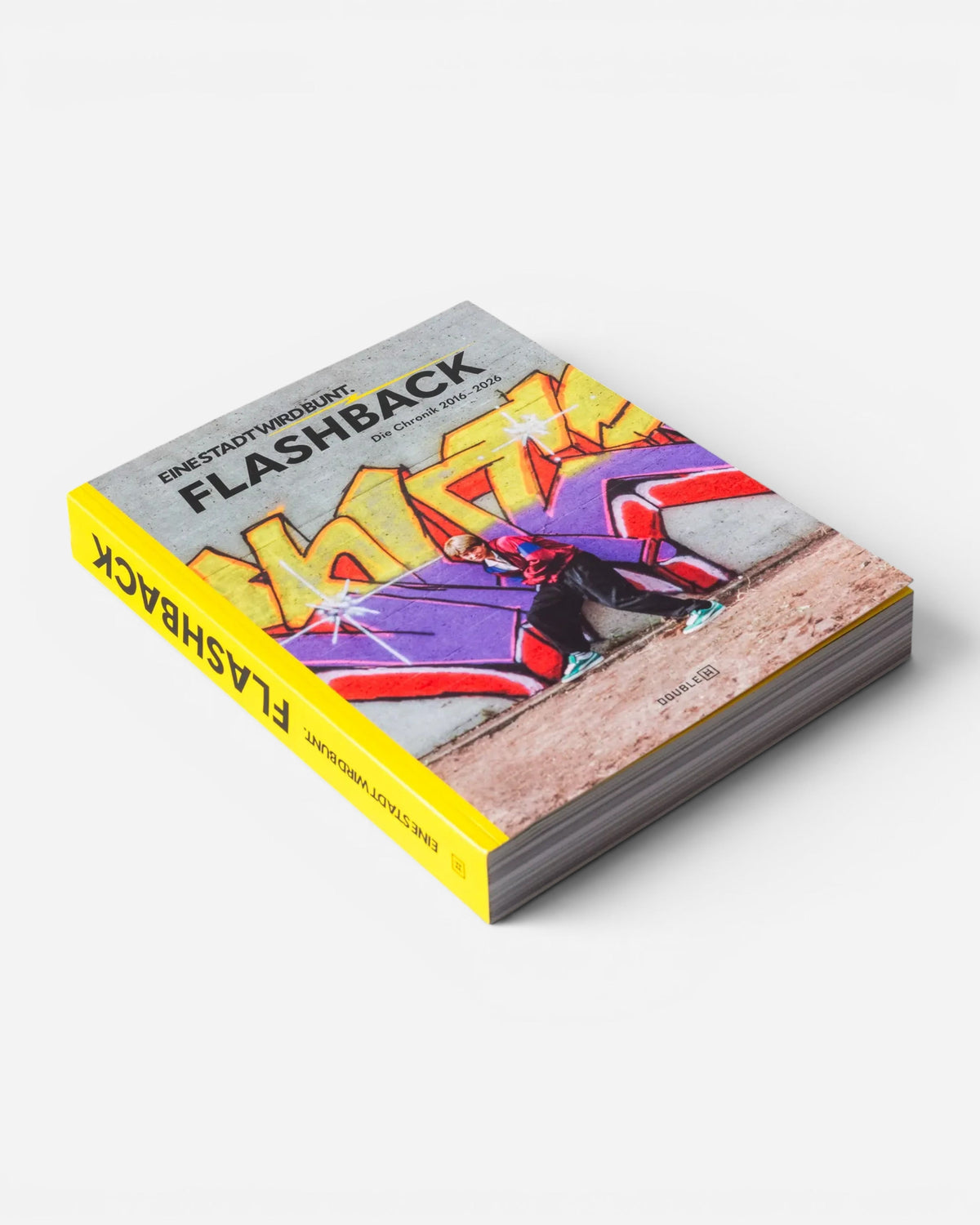 Astrofat EINE STADT WIRD BUNT. FLASHBACK book featuring vibrant graffiti art cover with a bright yellow spine.