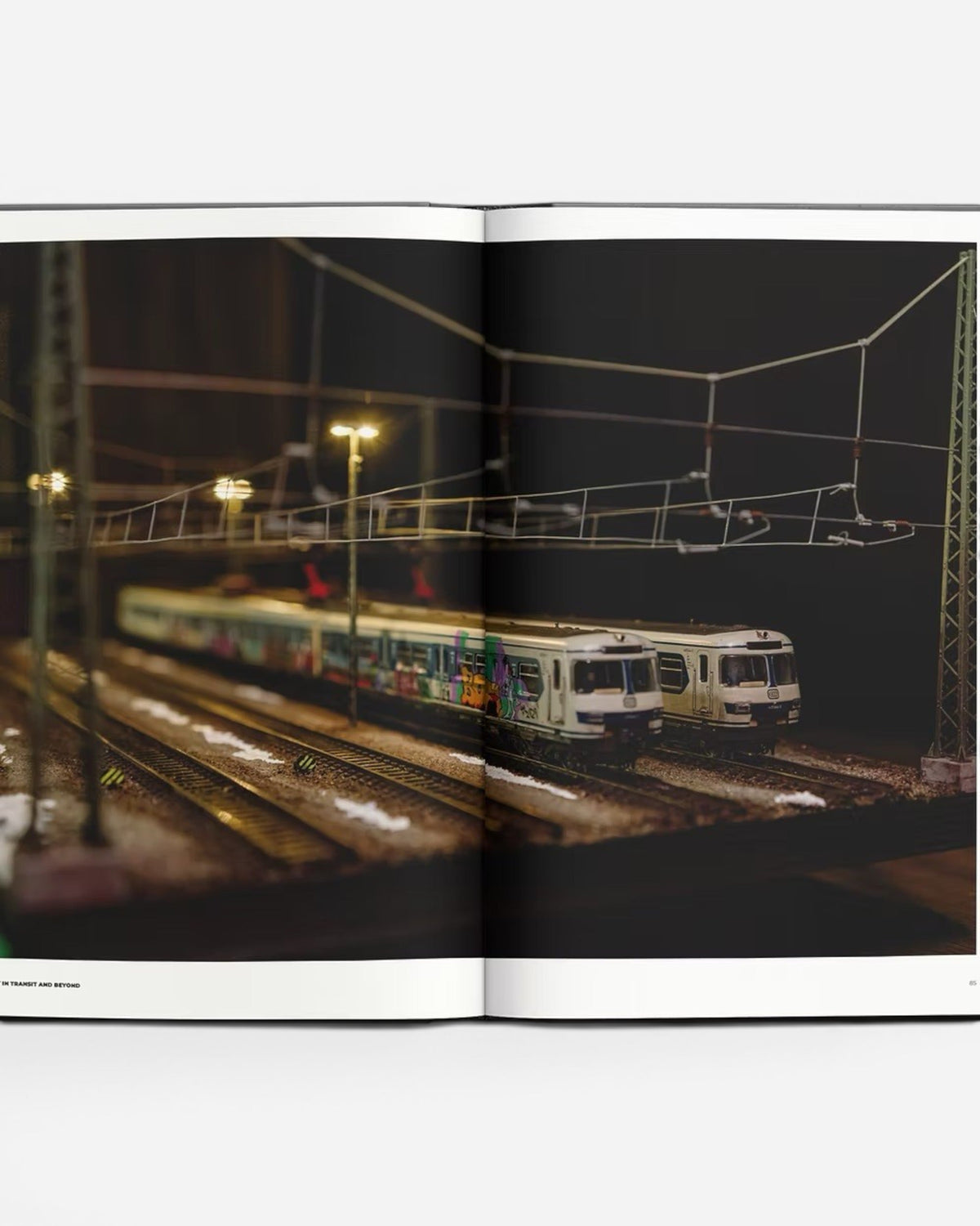 Astrofat Art In Transit And Beyond Hallenkunst book features model trains with graffiti art on tracks at night.