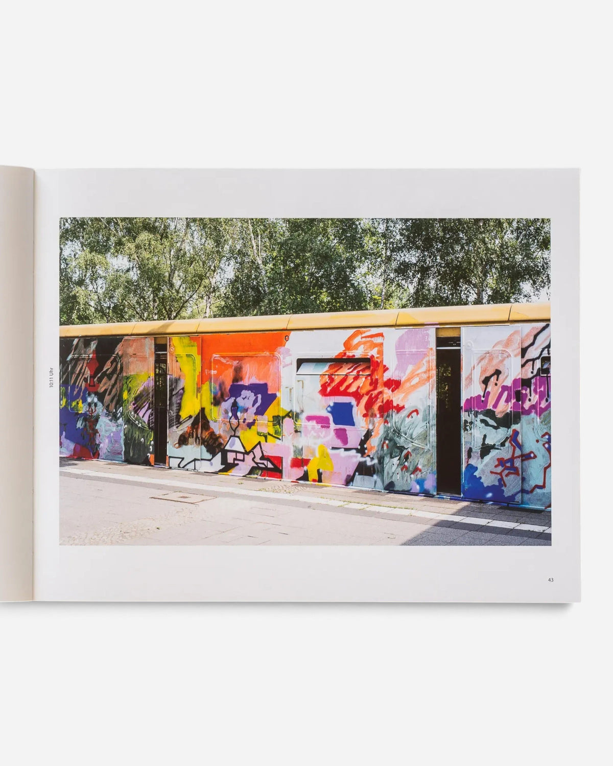 Astrofat Schriftzüge photobook open to a page showing a vibrant graffiti-covered Berlin S-Bahn train in daylight.