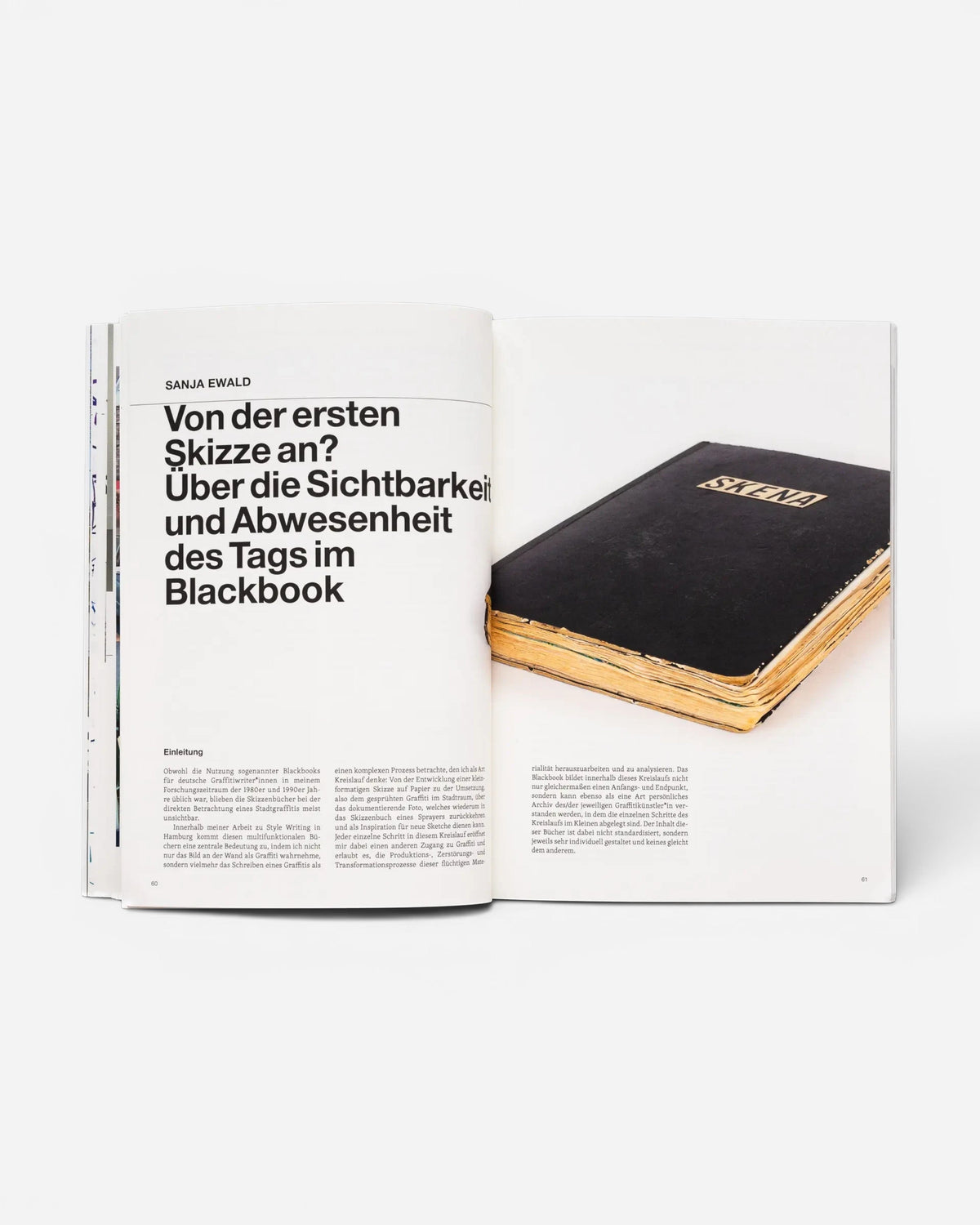 Astrofat TAG Name writing in public space book open to a page showing a black sketchbook with gold lettering