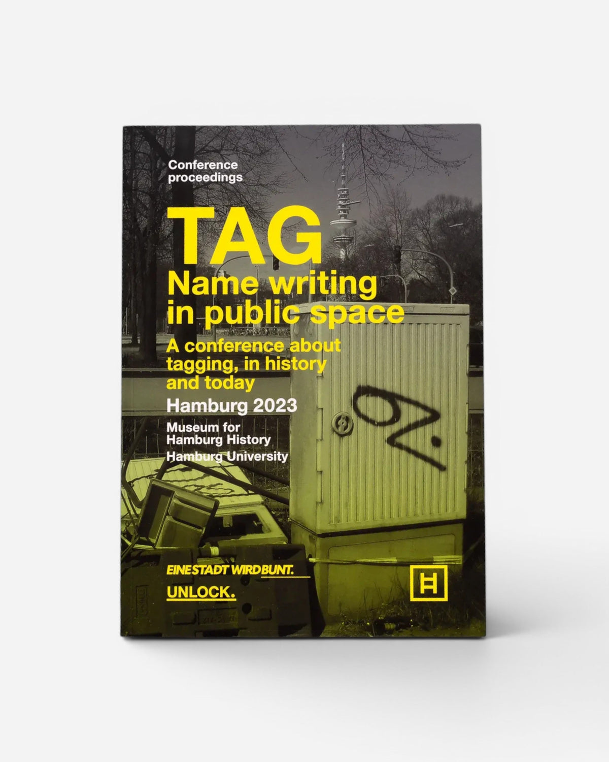 Astrofat TAG Name writing in public space book cover featuring yellow typography on a black and white Hamburg street scene