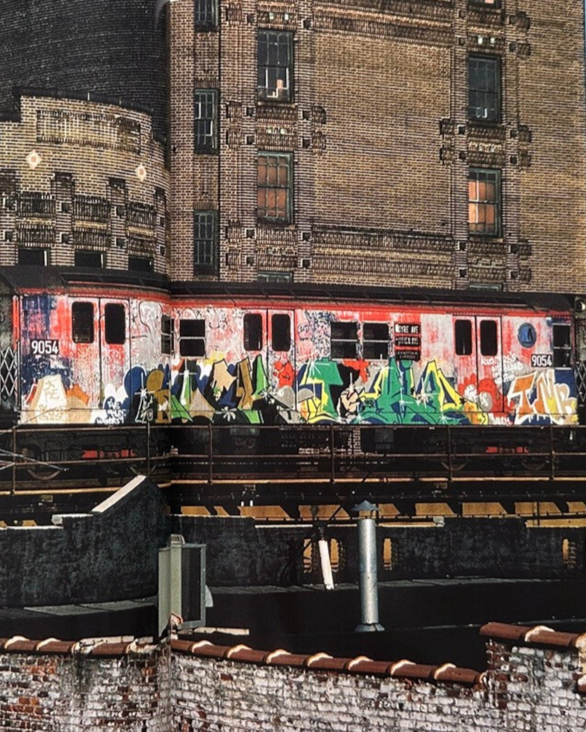 Astrofat book cover featuring a New York subway train covered in colorful graffiti, with brick buildings in the background.